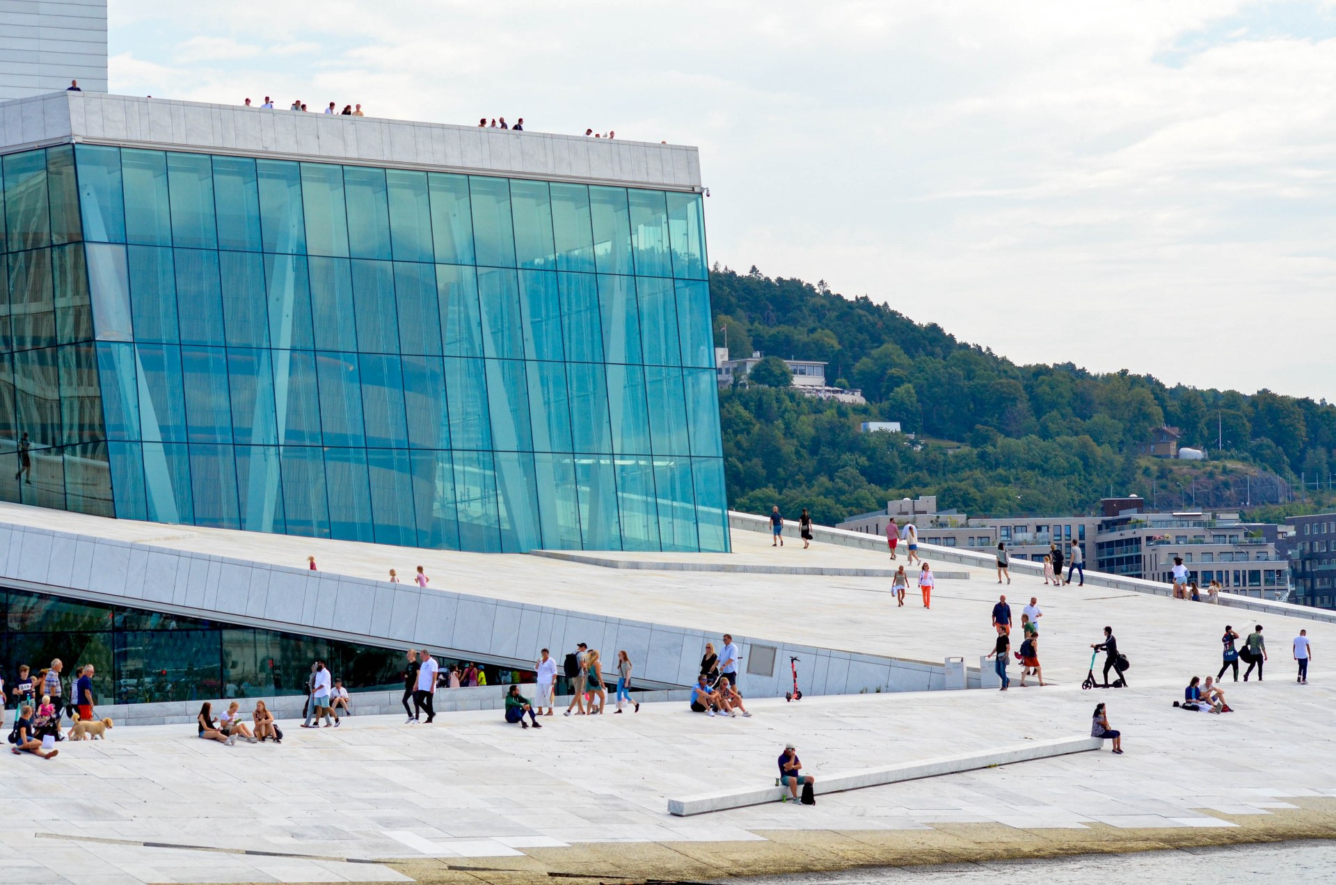Pessoas a passear e a descontrair no telhado da Ópera de Oslo